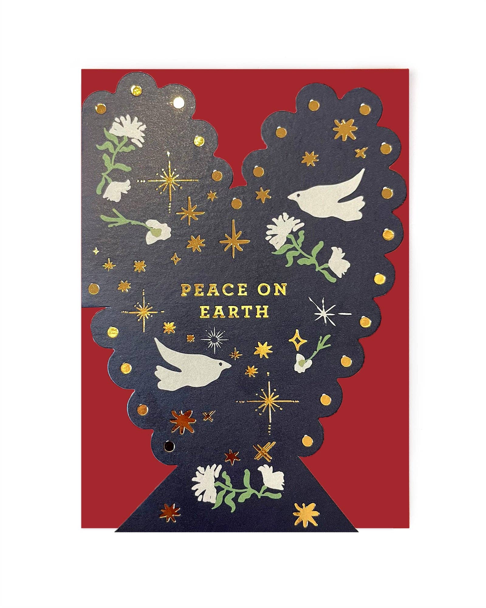 A christmas greeting card featuring a dark navy silhouette of a tree with white doves, gold stars, and flowers, with the text 'PEACE ON EARTH' in gold. The card is accompanied by a solid red envelope.