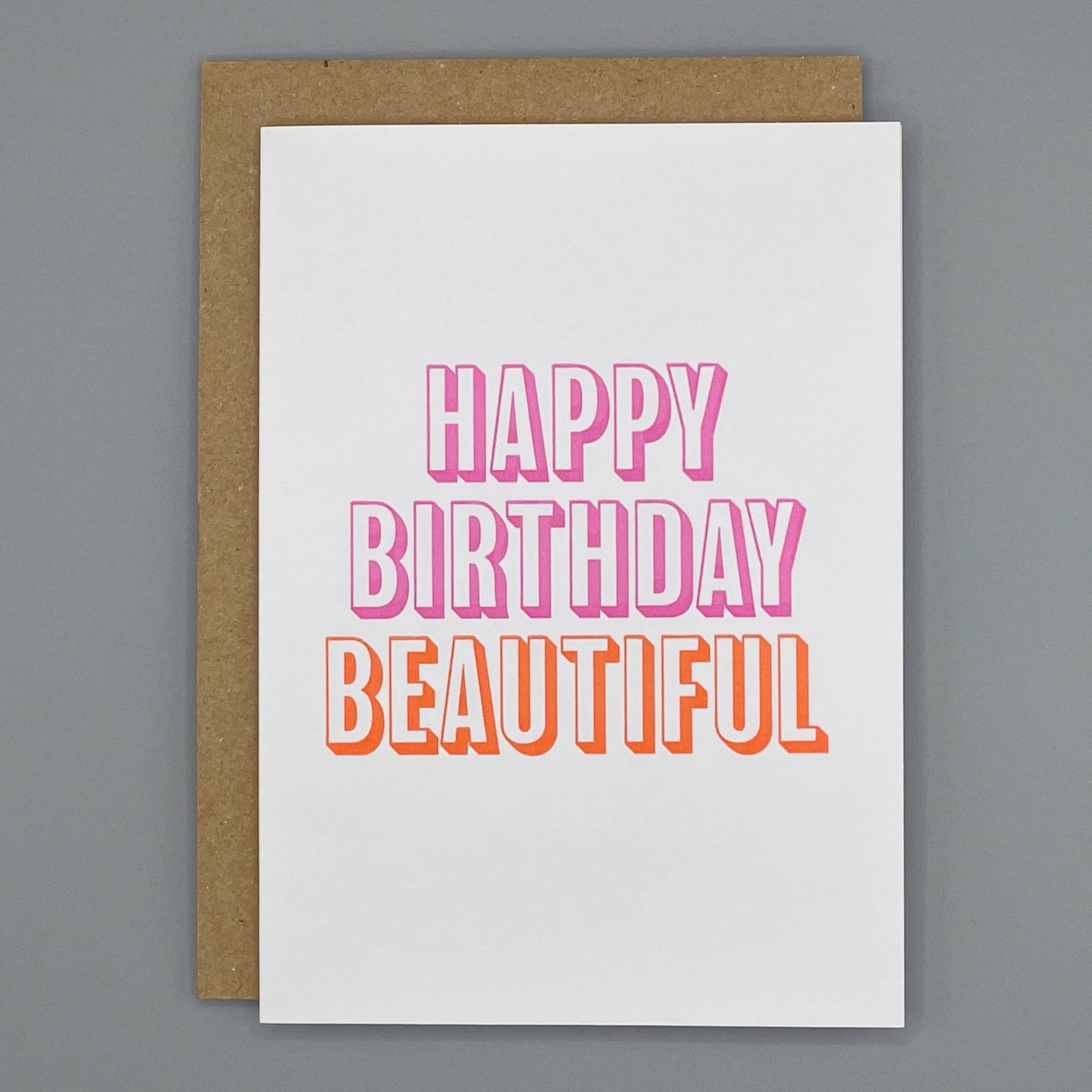 Letterpress birthday card with 'Happy Birthday Beautiful' bold block pink and orange text on a cream background