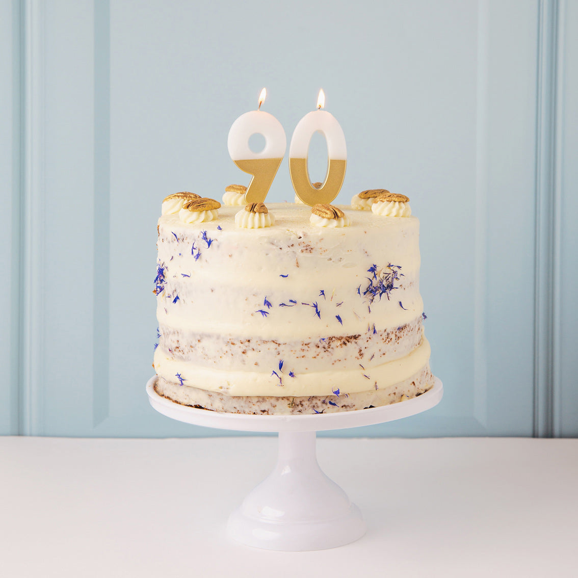 Gold & White Number Candle by talking tables at penny black - 90 on top of a naked cake on a cake stand.