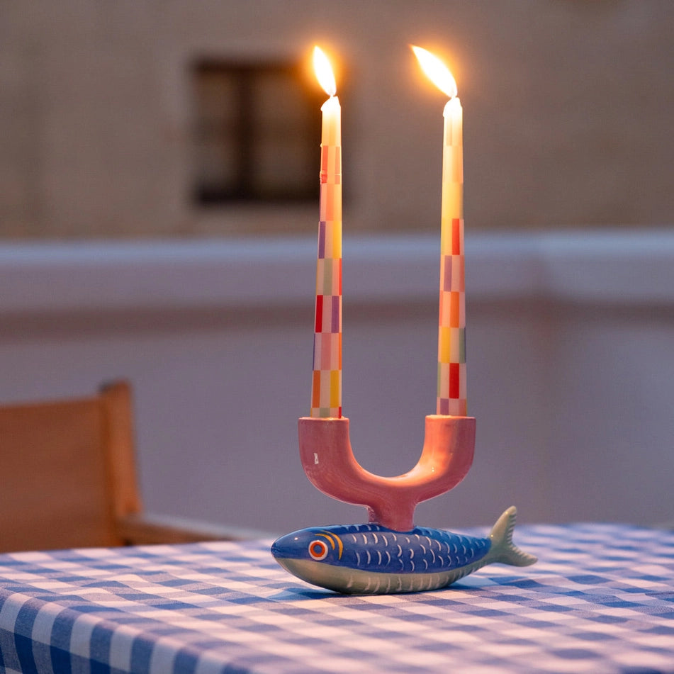 Pastel Check Dinner Candles 2 Pk by penny black shown in a candle holder shaped like a fish