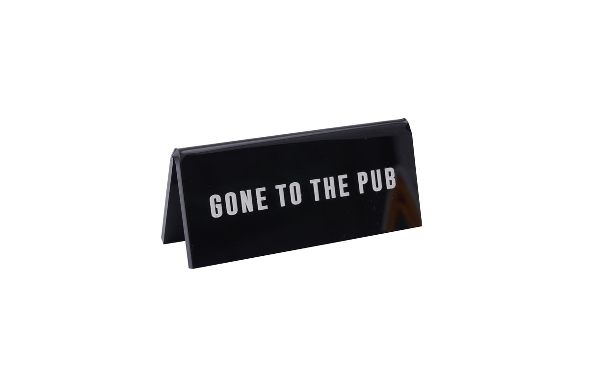 A small BLACK acrylic sign that has in big white capital letters on it 'GONE TO THE PUB'.