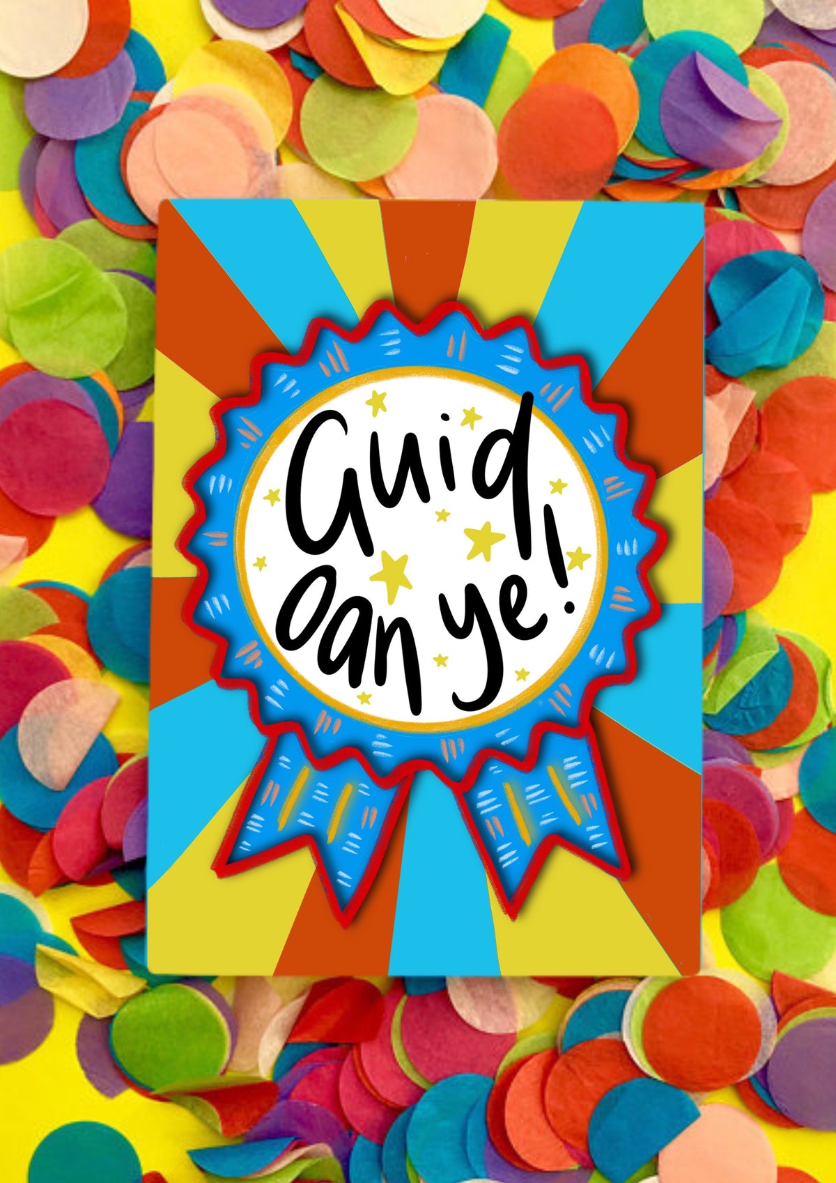 A greetings card with a stripey sunbeam designed background with a large rosette motif. The rosette is royal blue with red edging and has a large white circle in the middle that has the words handwritten 'guid oan ye'. The card is lying on a bed of rainbow confetti.