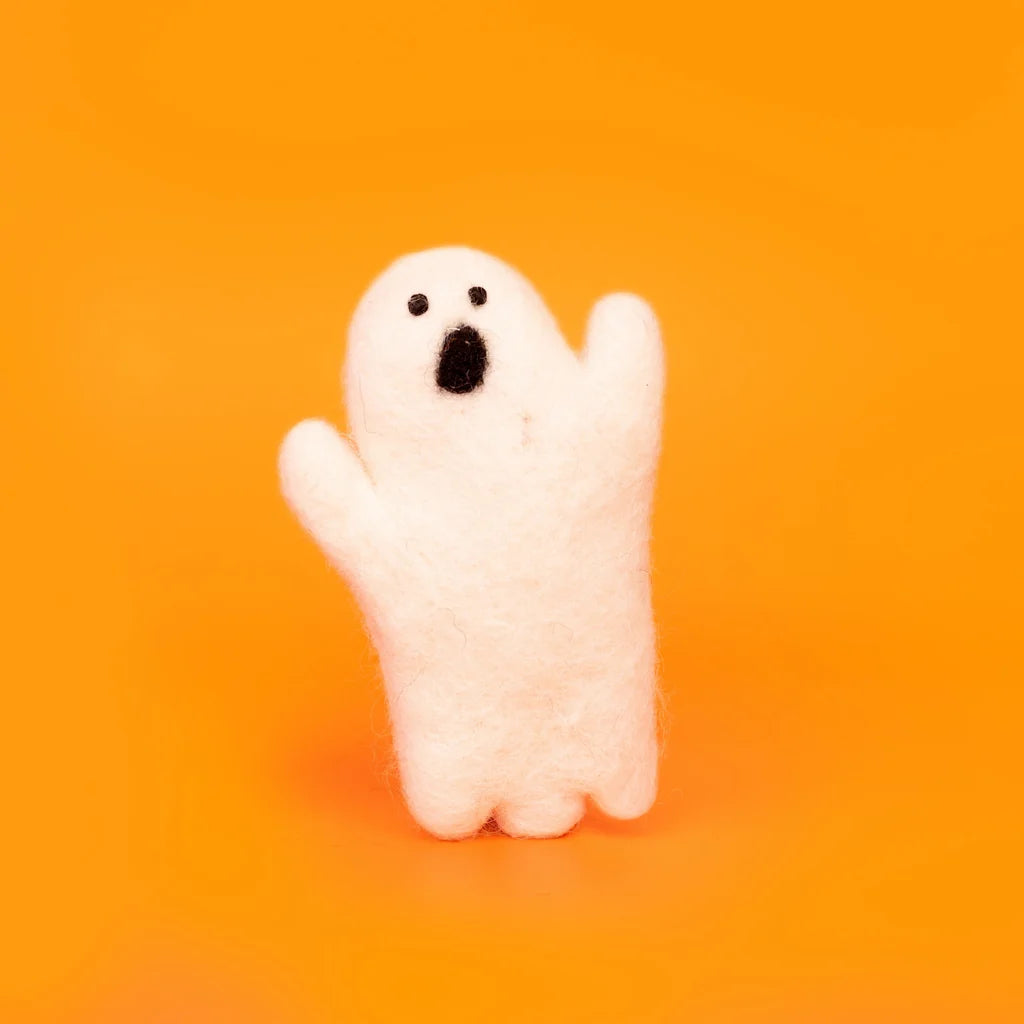 A small white felt halloween ghost figurine with a surprised face, standing against a solid orange background by Amica at Penny Black