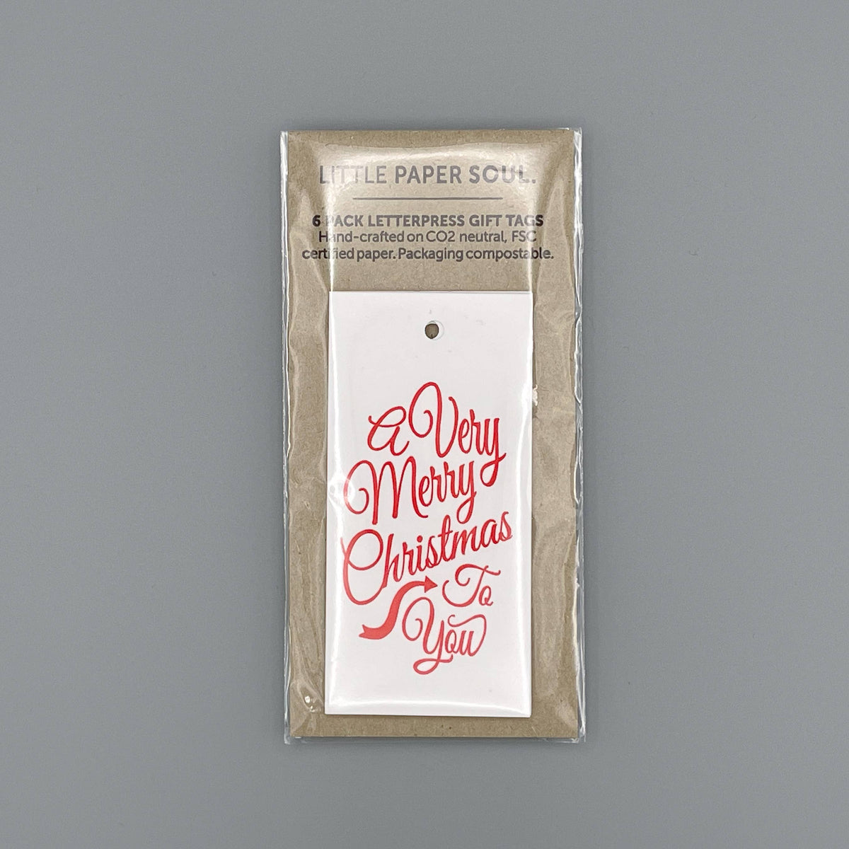 A packaged set of letterpress gift tags from Little Paper Soul, featuring a white tag with red cursive text reading 'A Very Merry Christmas To You' on a neutral grey background.