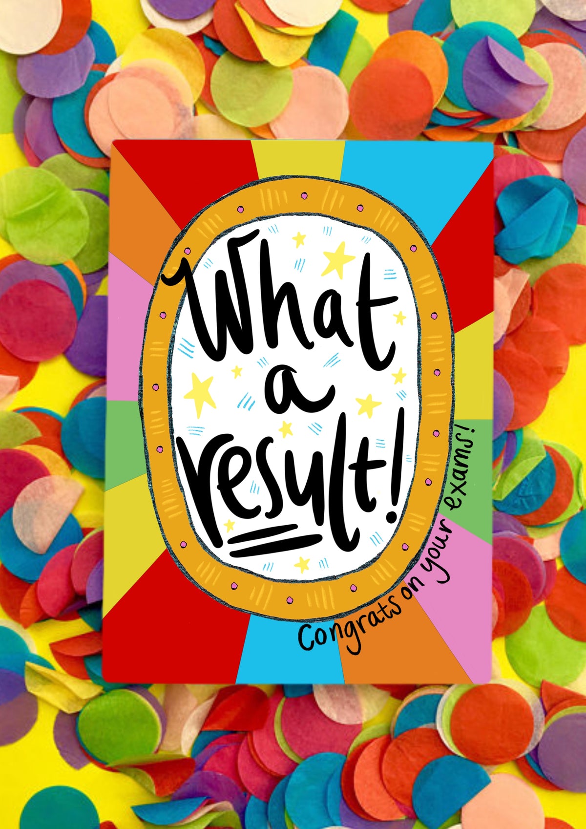 A greetings card with a rainbow sunbeam designed background with a large white circle motif in the middle that has the words handwritten 'what a result!'. Around the bottom right of the central motif are the words 'congrats on your exams'. The card is lying on a bed of rainbow confetti.